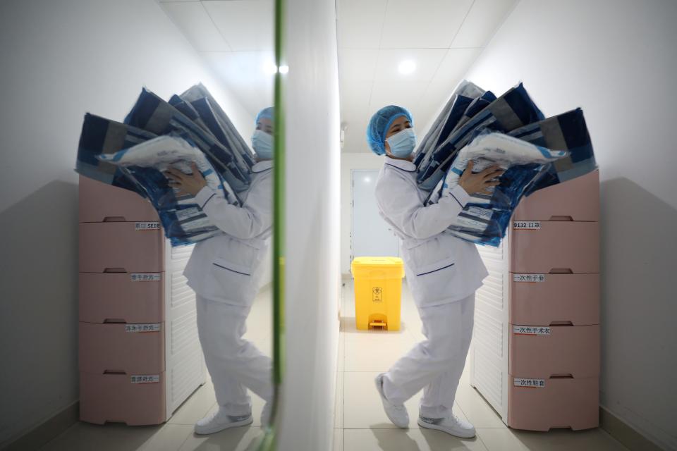 A medical worker carries protective suits at Jinyintan hospital in Wuhan, the epicentre of the novel coronavirus outbreak, in Hubei province, China February 13, 2020. China Daily via REUTERS 