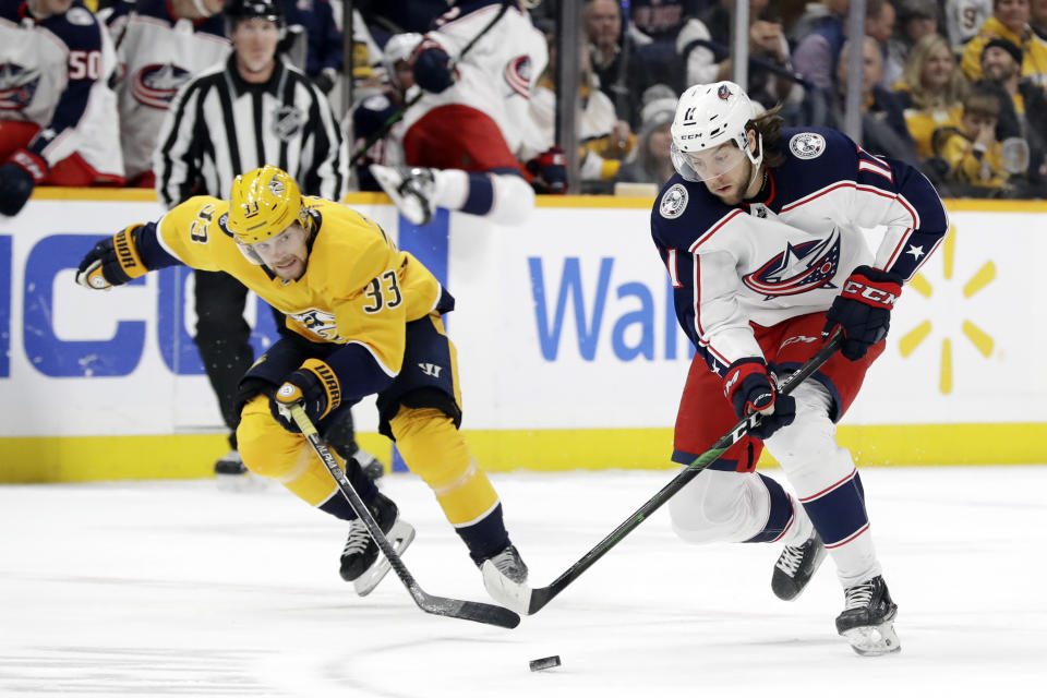 Columbus Blue Jackets center Kevin Stenlund (11) moves the puck ahead of Nashville Predators right wing Viktor Arvidsson (33), of Sweden, in the first period of an NHL hockey game Saturday, Feb. 22, 2020, in Nashville, Tenn. (AP Photo/Mark Humphrey)