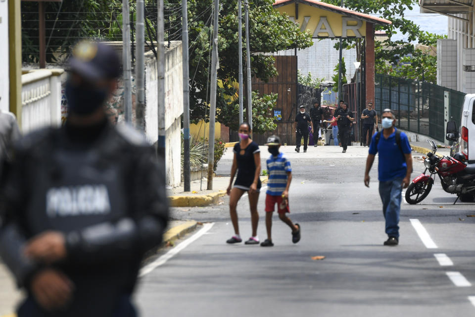 Security forces, back, leave a facility in the Macuto area in La Guiara, Venezuela, Sunday, May 3, 2020. Interior Nestor Reverol said on state television that Venezuelan forces overcame an armed maritime incursion by boats through the port city of La Guaira from neighboring Colombia before dawn Sunday, in which several attackers were killed and others detained. (AP Photo/Matias Delacroix)