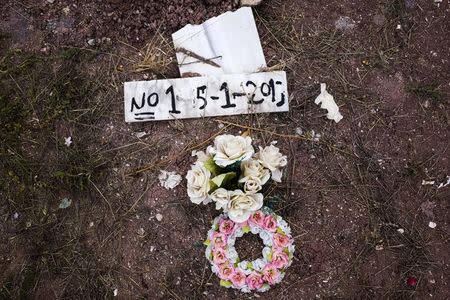 Flowers are placed on the grave of an unidentified migrant, who drowned at sea during an attempt to cross a part of the Aegean Sea from the Turkish coast, at the Saint Panteleimon cemetery of Mytilene, on the Greek island of Lesbos, October 7, 2015. REUTERS/Dimitris Michalakis