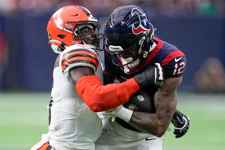 Houston Texans wide receiver Nico Collins is tackled by Cleveland Browns linebacker Jeremiah Owusu-Koramoah on Saturday in Houston.
