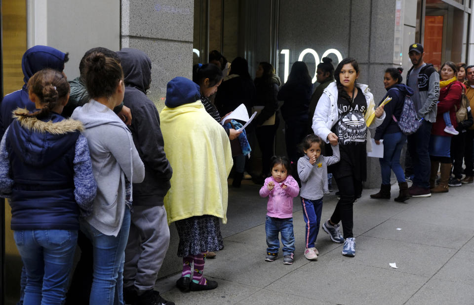 Hundreds of people overflow onto the sidewalk in a line snaking around the block outside a U.S. immigration office with numerous courtrooms Thursday, Jan. 31, 2019, in San Francisco. The crowd was mixed with people who had court appointments for Thursday, people whose appointments were swallowed up by shutdown and others who had 'Notices to Appear' but assumed that meant they had court dates. (AP Photo/Eric Risberg)