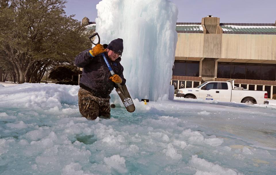 City of Richardson worker Kaleb Love breaks ice on a frozen fountain Tuesday, Feb. 16, 2021, in Richardson, Texas.   (AP Photo/LM Otero)