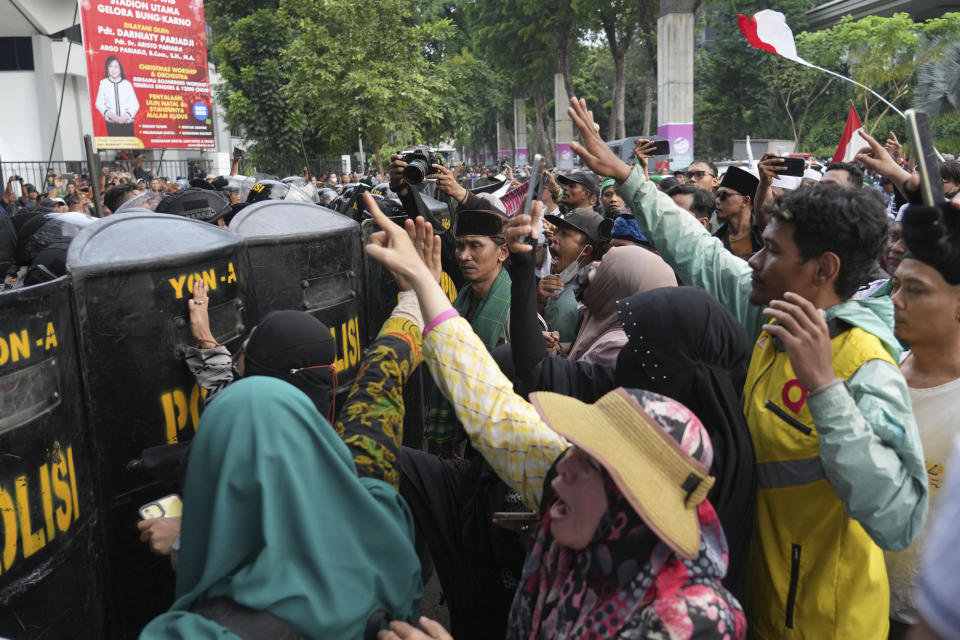 Muslims shout slogans during a rally against British band Coldplay ahead of its concert in Jakarta, Indonesia, Wednesday, Nov. 15, 2023. A group of conservative Muslims staged the rally calling for the cancellation of the concert over the band's support for the LGBTQ+ community. (AP Photo/Tatan Syuflana)