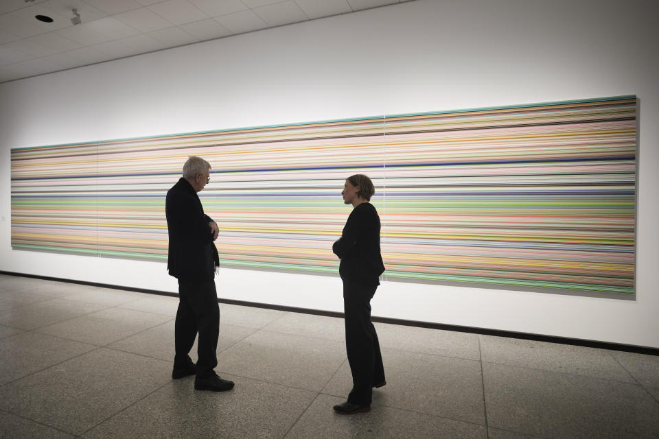 People looks to a painting 'Strip' in a new exhibition with art works of German artist Gerhard Richter at the New National Gallery in Berlin, Germany, Friday, March 31, 2023. Richter's foundation gave on permanent loan 100 works of the artist to the New National Gallery where they will be shown in the permanent exhibition. (AP Photo/Markus Schreiber)