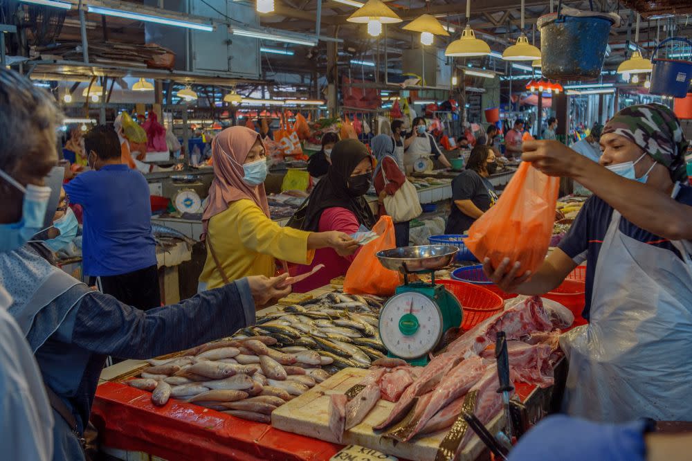 People wearing face masks shop for fresh seafood at the Chow Kit market in Kuala Lumpur November 25, 2021. — Picture by Shafwan Zaidon