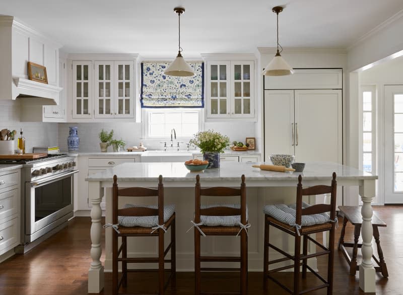 White kitchen with blue and white window shades and other small blue and white accents