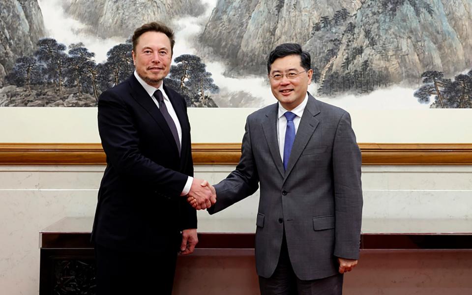 China's Foreign Minister Qin Gang, right, poses for photos with Tesla Ltd. CEO Elon Musk in Beijing - PRC Foreign Affairs Ministry via AP