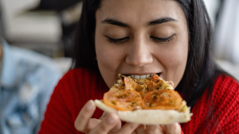 Woman eating leftover pizza