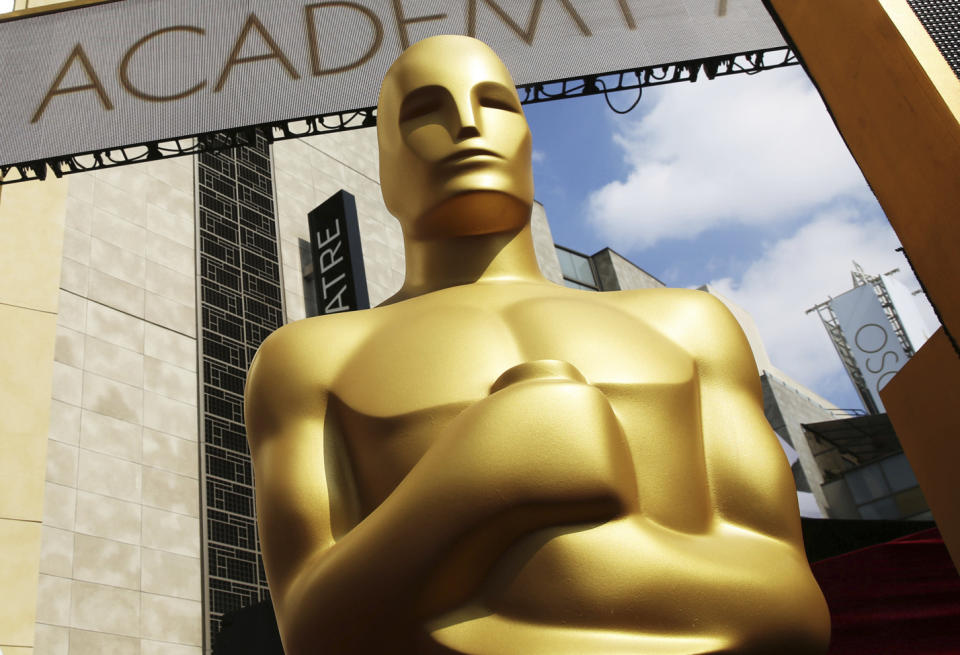 FILE - In this Feb. 21, 2015 file photo, an Oscar statue appears outside the Dolby Theatre for the 87th Academy Awards in Los Angeles. Some people watch awards shows out of love, others because they love to hate. But this year, as ratings have taken a dive, will anybody tune in to the Oscars? Pushed by the pandemic from its usual berth of February or early March, the Academy Awards will be presented April 25 on ABC. (Photo by Matt Sayles/Invision/AP, File)