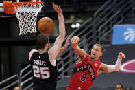 Toronto Raptors guard Malachi Flynn (8) makes a pass around San Antonio Spurs center Jakob Poeltl (25) during the second half of an NBA basketball game Wednesday, April 14, 2021, in Tampa, Fla. (AP Photo/Chris O'Meara)