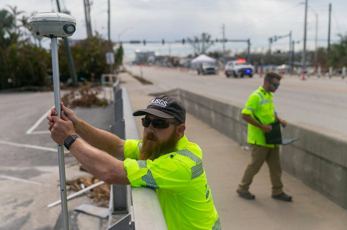 James Fountain, 40, with the U.S. Geological Survey, measures elevation using a GPS device near the Nauti Parrot Dock Bar on Tuesday, Oct. 18, 2022, in Fort Myers Beach, Florida.