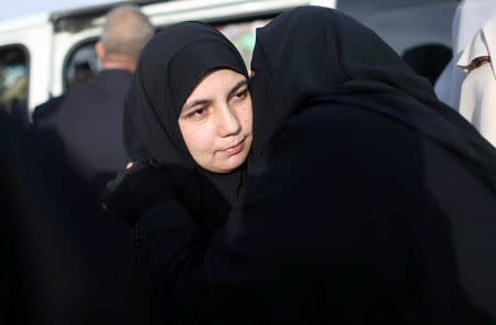 The wife of Palestinian engineering lecturer Fadi al-Batsh, who was shot dead in Malaysia, is hugged upon her husbandÕs body arrival in the southern Gaza Strip, April 26, 2018. REUTERS/Ibraheem Abu Mustafa