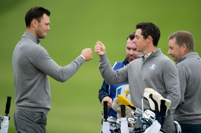 Rory McIlroy of Northern Ireland (2nd R) and Martin Kaymer of Germany (L) bump fists during a practice round in Chaska, Minnesota, September 28, 2016