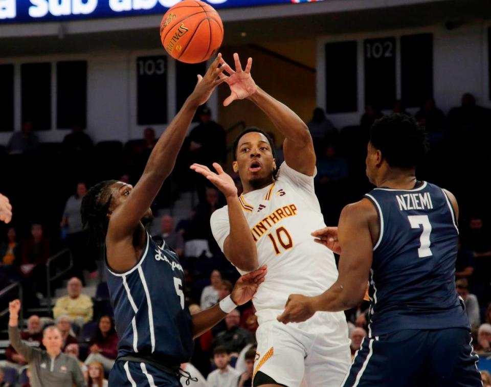 Winthrop’s Nick Johnson tries to pass the ball around Longwood’s Johnathan Massie (5) and Johan Nziemi Friday at the Big South Tournament.