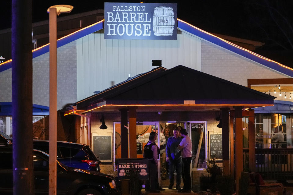 Police officers slowly allow patrons to evacuate the Fallston Barrel House as a manhunt for a gunman is underway in the vicinity, Thursday, Feb. 9, 2023, in Fallston, Md. A second police officer in Maryland has been injured in gunfire as Baltimore County police continue searching for a suspect amid a large manhunt that began after a different officer was shot Wednesday. (AP Photo/Julio Cortez)