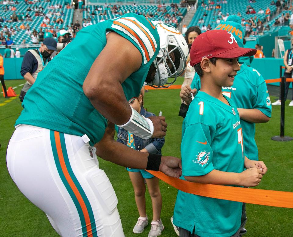 Dolphins quarterback Tua Tagovailoa, signing a fan's jersey before the final game of the season, remains popular with a lot of Miami fans.