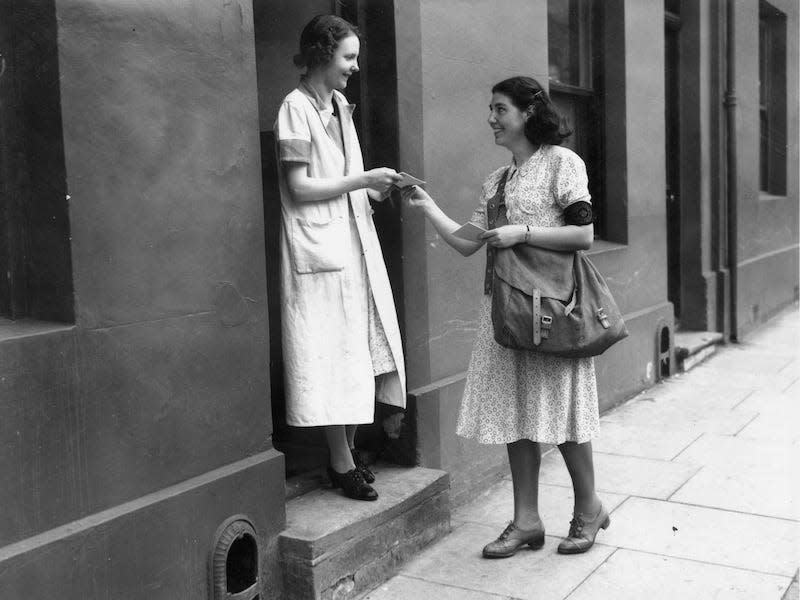 A female postal worker delivers mail in 1940.
