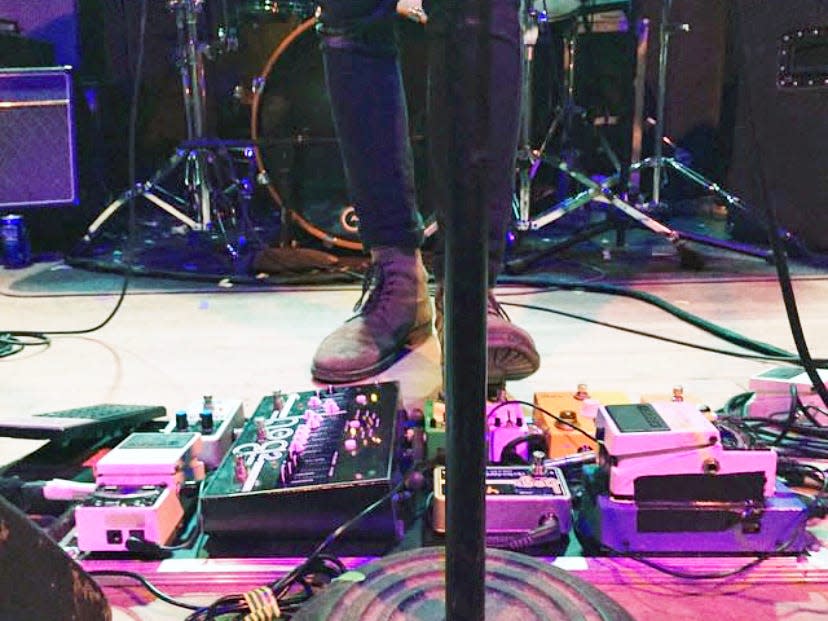 A close up of a foot on a pedal board at a concert