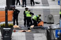 Police cars and ambulances rapidly flooded the scene after a truck ploughed into a crowd outside a busy department store in central Stockholm, killing four and injuring 15