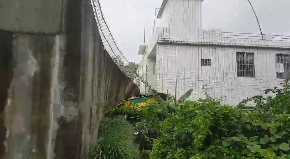 旗山的花旗路上，也有寺廟圍牆倒塌，壓在民宅鐵皮屋頂上。（警消提供）