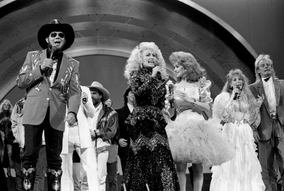 Host Dolly Parton sings with other county-music stars in the opening number of the CMA Awards show at the Grand Ole Opry House in 1988.