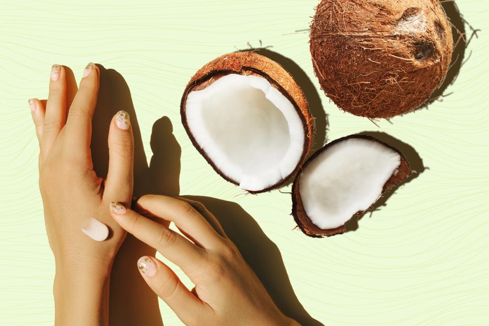 A hand applying loiton on another hand next to a coconut