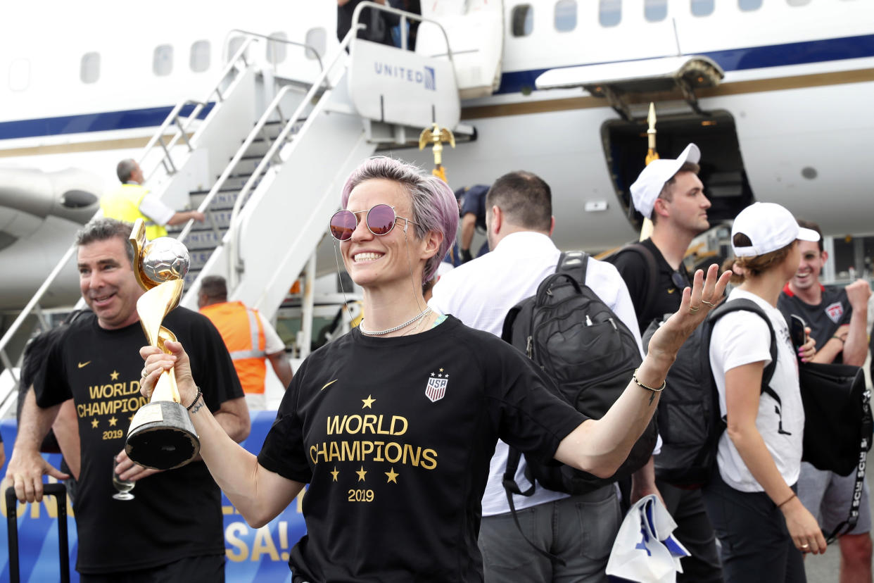 United States women's soccer team member Megan Rapinoe holds the Women's World Cup trophy after arriving with teammates at Newark Liberty International Airport, Monday, July 8, 2019, in Newark, N.J. (AP Photo/Kathy Willens)