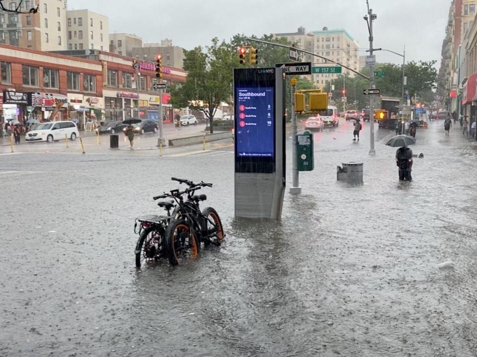 A person wades through the flood water near the 157th Street metro station (Reuters)