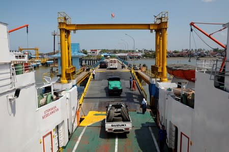 Cars leave a ferry boat as they arrive at North Penajam Paser port from Balikpapan in East Kalimantan province