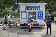 A worker wearing a protective suit registers people for COVID-19 tests at a coronavirus testing site in Beijing, Thursday, May 19, 2022. Parts of Beijing on Thursday halted daily mass testing that had been conducted over the past several weeks, but many testing sites remained busy due to requirements for a negative COVID test in the last 48 hours to enter some buildings in China's capital. (AP Photo/Mark Schiefelbein)