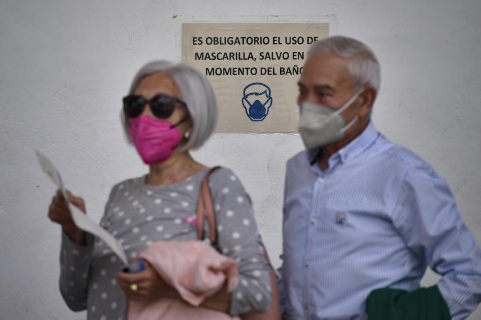 FILE - In this May 13, 2021, file photo, people wait for the Pfizer vaccine during a COVID-19 vaccination campaign in Alfaro, northern Spain. Coronavirus infections, hospitalizations and deaths are plummeting across much of Europe. Vaccination rates are accelerating, and with them, the promise of summer vacations. (AP Photo/Alvaro Barrientos, File)