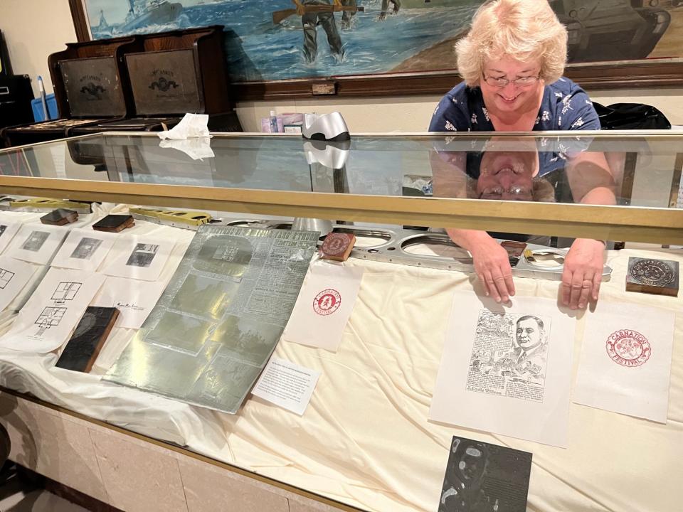 Karen Perone, president of the Alliance Historical Society, arranges a display of printing blocks and prints made from them inside the Alliance History Mini Museum.