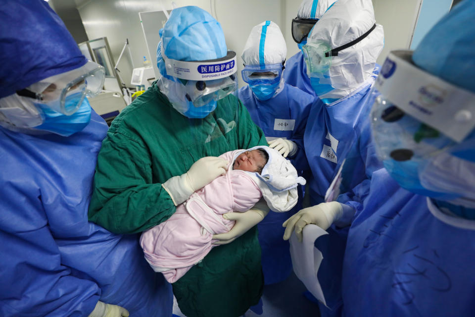 A midwife shows the newborn to the present medical workers after the Cesarean section operation on a suspected COVID-19 patient in Wuhan Union Hospital in Wuhan in central China's Hubei province Saturday, March 07, 2020. The hospital's Ob/Gyn department has been designated to take care of women of the novel coronavirus disease since the outbreak. (Feature China/Barcroft Media via Getty Images)