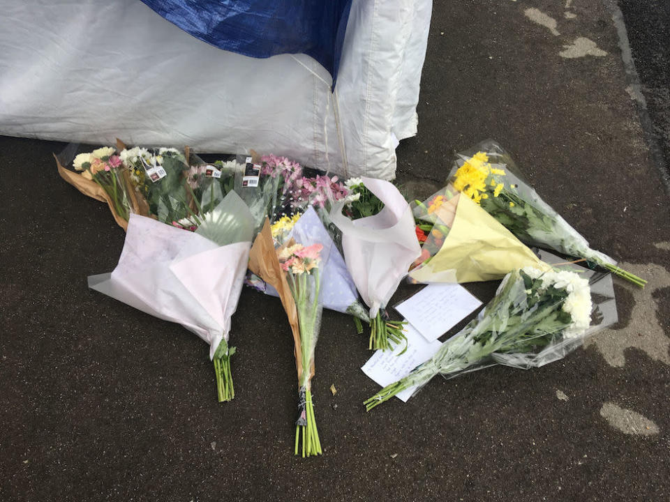 Tributes were left outside the entrance to the block of flats in Enfield (Picture: PA)