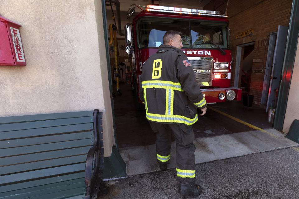 Firefighter Rod MacKinnon wears his turnout gear as he enters the Engine 21 fire station, Thursday, Aug. 24, 2023, in the Dorchester neighborhood of Boston. (AP Photo/Michael Dwyer)