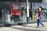 A shopper walks by a store, Monday, Nov. 18, 2020 in Pembroke Pines, Fla. After months of slumping sales and businesses toppling into bankruptcy, Black Friday is offering a small beacon of hope. In normal times, Black Friday is the busiest shopping day of the year, drawing millions of shoppers eager to get started on their holiday spending. But these are not normal times.(AP Photo/Marta Lavandier)