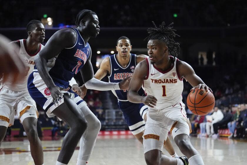 USC guard Isaiah Collier dribbles in front of Arizona defenders on Saturday at the Galen Center.