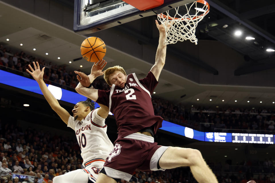 Texas A&M guard Hayden Hefner (2) is fouled by Auburn guard Chad Baker-Mazara (10) as he goes up for a dunk during the first half of an NCAA college basketball game Tuesday, Jan. 9, 2024, in Auburn, Ala. (AP Photo/Butch Dill)