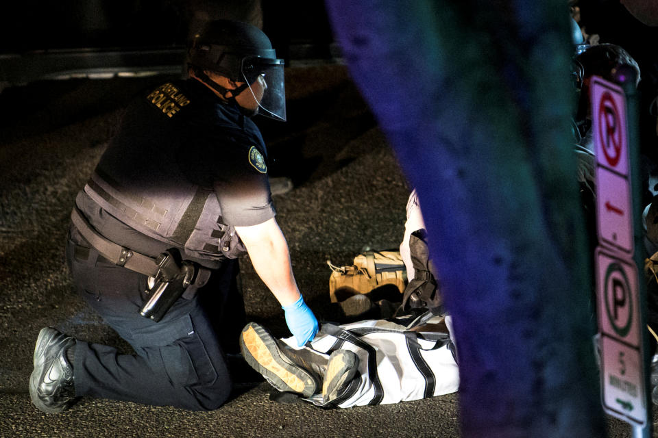 A police officer checks the body of a man who was shot dead