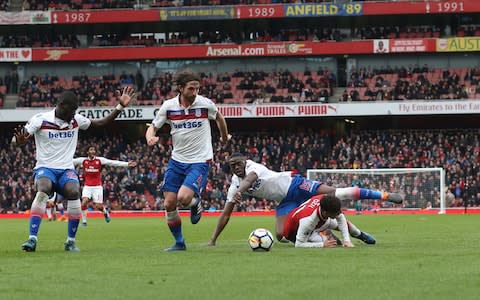 Mesut Ozil goes down in the box under challenge from Bruno Martins Indi - Credit: GETTY IMAGES