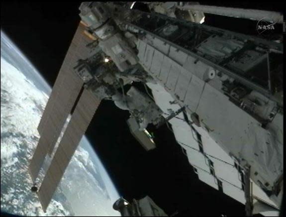 Japanese spacewalker Akihiko Hoshide is pictured holding a failed power switching unit during a spacewalk on Aug. 30, 2012. In the photo, Hoshide is riding on the end of the space station's robotic arm.