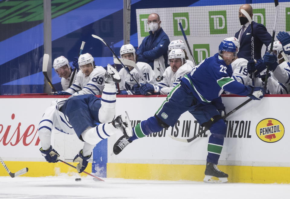 Vancouver Canucks' Alexander Edler, right, of Sweden, and Toronto Maple Leafs' Zach Hyman collide during the second period of an NHL hockey game in Vancouver, British Columbia, Sunday, April 18, 2021. Edler received a major penalty for kneeing and game misconduct on the play. (Darryl Dyck/The Canadian Press via AP)