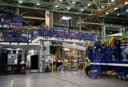 Employees work on part of the 777X wing assembly during a media tour of the Boeing 777X at the Boeing production facility in Everett