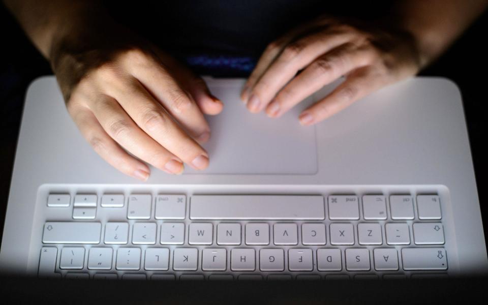 Hands typing at a laptop keyboard