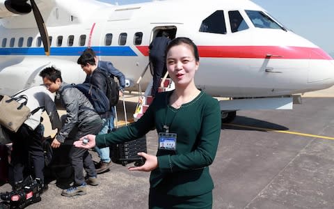 A North Korean airport official guiding South Korean journalists upon their arrival at North Korea's Kalma airport in Wonsan - Credit: Getty