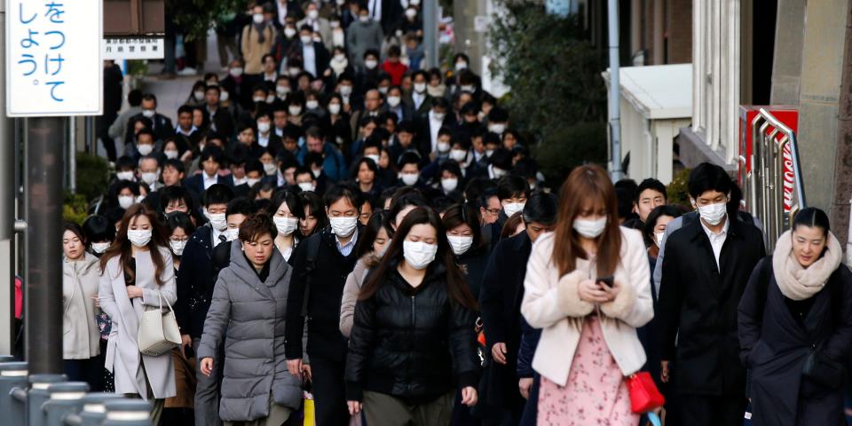 FILE - In this Feb. 20, 2020, file photo, people wear masks as they commute during the morning rush hour in Chuo district in Tokyo. China's massive travel restrictions, house-to-house checks, huge isolation wards and lockdowns of entire cities bought the world valuable time to prepare for the global spread of the new virus. (AP Photo/Kiichiro Sato, File)