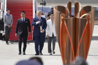 Tokyo 2020 Olympics chief Yoshiro Mori, center, followed by three-time Olympic gold medalists Tadahiro Nomura and Saori Yoshida, right, carries the Olympic flame during the Flame Arrival Ceremony at Japan Air Self-Defense Force Matsushima Base in Higashimatsushima in Miyagi Prefecture, north of Tokyo, Friday, March 20, 2020. The Olympic flame from Greece arrived in Japan even as the opening of the the Tokyo Games in four months is in doubt with more voices suggesting the games should to be postponed or canceled because of the worldwide virus pandemic. (AP Photo/Eugene Hoshiko)