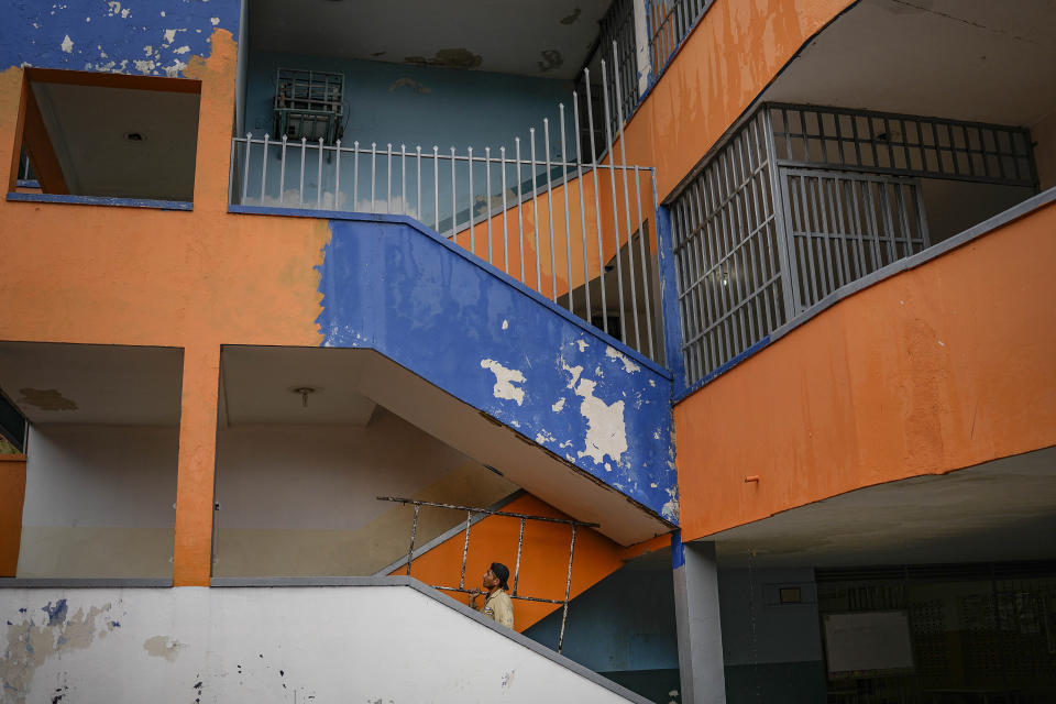 FILE - A worker carries scaffolding during repairs at a public school in Caracas, Venezuela, Wednesday, Aug. 10, 2022. A few days into their long break, teachers have been marching by the thousands around the country, threatening to strike when school resumes or possibly even to abandon their profession after the government paid them only a tiny fraction of their annual vacation bonus. (AP Photo/Matias Delacroix, File)