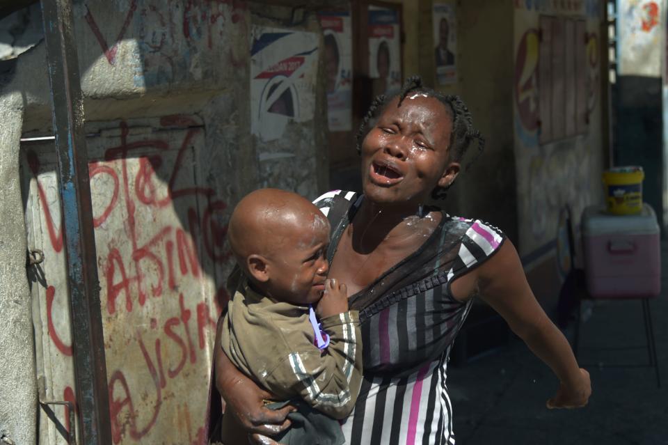 A woman reacts to tear gas fired by the Haitian National Police during clashes with supporters of presidential candidate Maryse Narcisse, in the neighborhood of La Saline, in the Haitian capital Port-au-Prince, on Nov. 29, 2016.&nbsp;